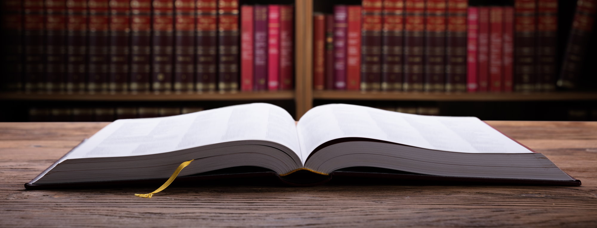 Close-up Of An Open Law Book On Wooden Desk In Courtroom